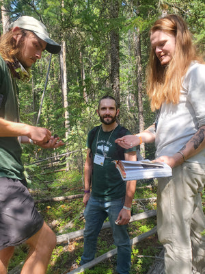 Foragers in the forest look at their mushroom and books at the NAMA annual foray.